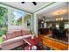 Bright sunroom with comfortable seating and views leading into the open concept kitchen and dining area at 127 White Pine Way, Summerville, SC 29485