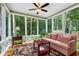 Bright sunroom with large windows offering serene wooded views and a comfortable seating area at 127 White Pine Way, Summerville, SC 29485
