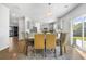 Well-lit dining room with table, six chairs, gray walls and access to kitchen and sliding glass door at 1309 Berry Grove Dr, Summerville, SC 29485