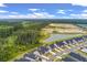 An aerial view highlights a neighborhood near a pond with natural landscape including trees and open land at 1384 Locals St, Summerville, SC 29485