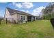 Fenced backyard with screened porch, grassy lawn, and view of the neighboring houses at 1384 Locals St, Summerville, SC 29485