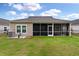 Backyard features a screened-in porch with dark screens, green grass, and an AC unit at 1384 Locals St, Summerville, SC 29485