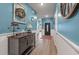 Bright and inviting hallway with hardwood floors, wainscoting and light blue paint at 1384 Locals St, Summerville, SC 29485