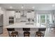 Well-lit kitchen featuring white cabinets, stainless steel appliances, a central island and wood breakfast stools at 1384 Locals St, Summerville, SC 29485