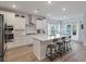 Bright and modern kitchen with white cabinets, stainless steel appliances, and center island with breakfast bar at 1384 Locals St, Summerville, SC 29485