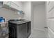 Modern laundry room with front-loading washer and dryer, storage shelves, and tile flooring at 1384 Locals St, Summerville, SC 29485