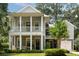 A two story home features double porches, gray paint, mature trees and manicured landscaping at 1405 Mataoka St, Mount Pleasant, SC 29464