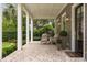 Inviting front porch with brick flooring, comfortable seating, and charming outdoor lighting fixtures at 1405 Mataoka St, Mount Pleasant, SC 29464