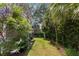 Landscaped side yard with lush greenery, including palms and flowering plants, offering a tranquil outdoor space at 1405 Mataoka St, Mount Pleasant, SC 29464