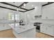 Bright, modern kitchen featuring white cabinets, wooden beams, and a large island with marble countertops at 142 Argosy Dr, Summerville, SC 29483