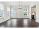 Bright dining room with large windows, dark hardwood floors, and decorative lighting fixture at 1427 Dahlia Rd, Mount Pleasant, SC 29464