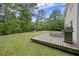 Backyard view featuring a deck, grill, seating, and fire pit nestled among mature trees at 1506 Southwick Dr, Johns Island, SC 29455