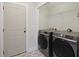 Well-lit laundry room featuring tile flooring and gray front load washer and dryer at 1506 Southwick Dr, Johns Island, SC 29455