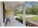 Inviting front porch with white columns, black metal chair and landscaped flower bed at 1506 Southwick Dr, Johns Island, SC 29455