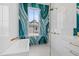 Bright bathroom featuring gorgeous teal and gold accent wall, soaking tub, and glass walk-in shower at 156 Nobels Point St, Charleston, SC 29492