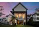 Striking modern home featuring expansive windows and contemporary design at twilight at 156 Nobels Point St, Charleston, SC 29492