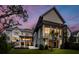Stunning modern home featuring an in-ground pool, manicured lawn, and an open-air patio at dusk at 156 Nobels Point St, Charleston, SC 29492