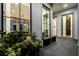 Elegant front porch with views into the dining room and kitchen through expansive black frame windows at 156 Nobels Point St, Charleston, SC 29492