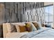Closeup of stylish main bedroom showcasing textured wall, throw pillows, and comfortable bedding at 156 Nobels Point St, Charleston, SC 29492