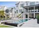 Backyard pool area showcasing a modern home with an outdoor kitchen and staircase at 156 Nobels Point St, Charleston, SC 29492
