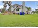 Green backyard featuring a wood deck, lush lawn, privacy fence, and mature palm trees at 16 Oatly Cir, Charleston, SC 29414