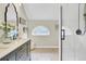 Modern bathroom with double sink vanity, half-moon accent window, and glass-enclosed shower at 16 Oatly Cir, Charleston, SC 29414