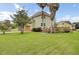 Large home featuring a lush lawn, garage, deck, palm trees, and verdant surroundings at 16 Oatly Cir, Charleston, SC 29414