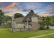 Charming home with brick accents, manicured lawn and inviting front porch at sunset at 16 Oatly Cir, Charleston, SC 29414