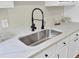 Close-up of kitchen sink with matte faucet and quartz countertops, creating a modern and clean look at 16 Oatly Cir, Charleston, SC 29414