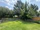 Large, grassy backyard with a wood fence, mature trees, and plenty of space for outdoor activities at 1705 Falcon Cove Ln, Hanahan, SC 29410