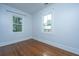 A bright and airy bedroom with hardwood floors and two windows provides plenty of natural light at 173 Fishburne St, Charleston, SC 29403
