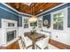 Dining room features a rustic wooden table, white cushioned chairs, wood ceiling, and decorative lighting at 173 Fishburne St, Charleston, SC 29403