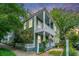 Charming two-story home with double porches and white picket fence, surrounded by lush greenery at 173 Fishburne St, Charleston, SC 29403