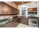 Kitchen featuring wood accents, dark cabinetry, stainless steel appliances, and granite countertops at 173 Fishburne St, Charleston, SC 29403