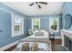 Cozy main bedroom features three windows, ceiling fan, fireplace, and hardwood floors at 173 Fishburne St, Charleston, SC 29403