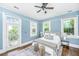 Main bedroom has a ceiling fan, beautiful natural light, hardwood floors, and ensuite access at 173 Fishburne St, Charleston, SC 29403