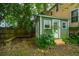 Charming green garden shed with white trim, surrounded by lush landscaping and a brick patio at 173 Fishburne St, Charleston, SC 29403