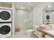 Modern bathroom featuring a glass shower, pink vessel sink, and convenient stacked washer and dryer at 1815 Long Bend Dr, Seabrook Island, SC 29455