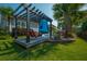 Inviting backyard with pergola, comfortable seating, lush lawn, and tropical landscaping near the pool at 185 Red Leaf Blvd, Moncks Corner, SC 29461