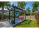 Backyard pergola swing surrounded by lush greenery and manicured lawn, perfect for outdoor relaxation and enjoyment at 185 Red Leaf Blvd, Moncks Corner, SC 29461