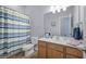 Bathroom features a vanity, a toilet, a shower with a blue shower curtain, and a big mirror at 185 Red Leaf Blvd, Moncks Corner, SC 29461
