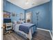 Charming bedroom with blue walls, a bed with blue bedding, hardwood floors, and natural light from the window at 185 Red Leaf Blvd, Moncks Corner, SC 29461