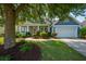 Charming home featuring a manicured front lawn, tree, and a welcoming facade with covered porch and attached garage at 185 Red Leaf Blvd, Moncks Corner, SC 29461