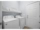 Functional laundry room features a washer, a dryer, storage shelving, and an entry/exit door at 185 Red Leaf Blvd, Moncks Corner, SC 29461