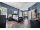 Spacious main bedroom features a dark color scheme, wood floors, and natural light at 185 Red Leaf Blvd, Moncks Corner, SC 29461