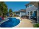 Beautiful backyard with a sparkling pool, hot tub, outdoor seating, and lush landscaping at 185 Red Leaf Blvd, Moncks Corner, SC 29461