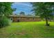 Lush backyard featuring well-maintained lawn, brick exterior of the home, and leafy trees surrounding property at 2003 Savage Rd, Charleston, SC 29407
