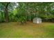 Spacious backyard featuring a shed, bordered by lush trees, offering both storage and natural beauty at 2003 Savage Rd, Charleston, SC 29407