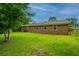 Backyard view of this single-story home with a large grass area, brick exterior, and fenced perimeter at 2003 Savage Rd, Charleston, SC 29407