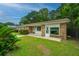 A quaint single-story home with brick accents, surrounded by lush greenery and a well-kept lawn at 2003 Savage Rd, Charleston, SC 29407